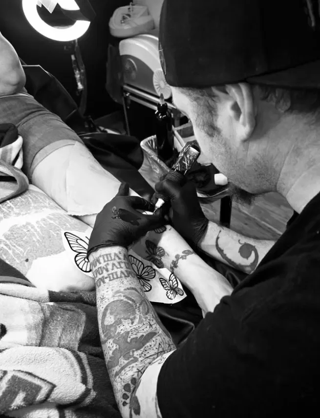 Tattoo apprentice Alex Iverson tattooing a client